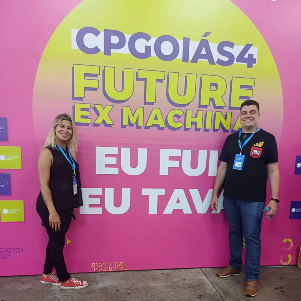Participantes na Campus Party Goiás 2024, painel colorido.