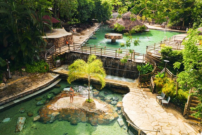 Paisagem tropical com lago e vegetação abundante.