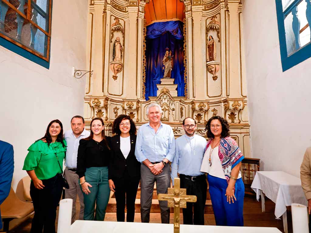Pessoas em frente a altar de igreja histórica.