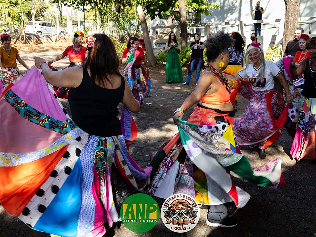 Grupo dançando com saias coloridas ao ar livre.