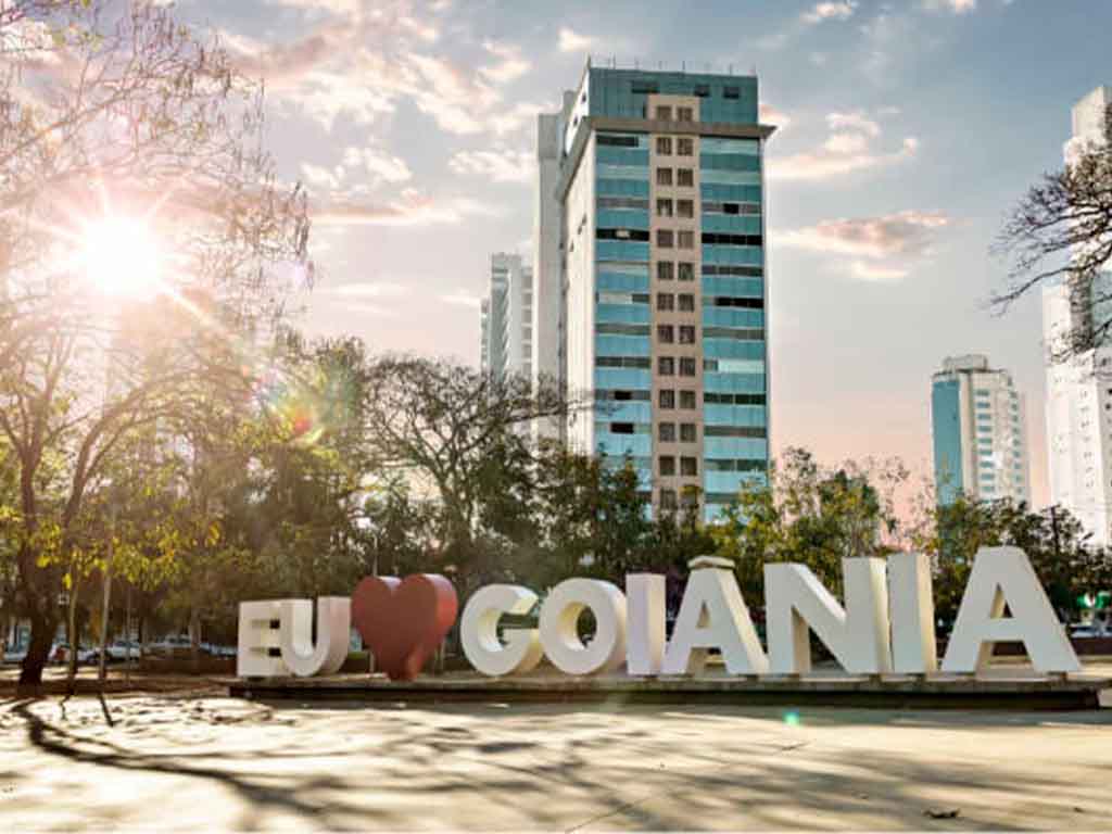 Placa Eu Amo Goiânia e prédios ao fundo.