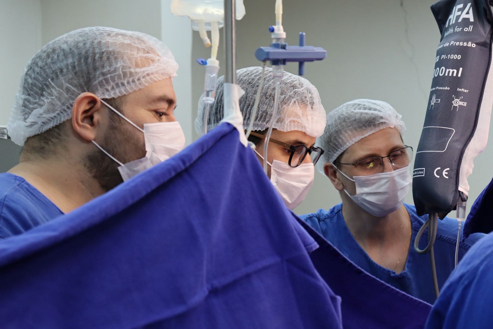 Médicos em cirurgia usando máscaras e toucas.