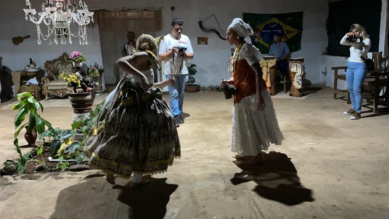 Dançarinas em trajes tradicionais performam em ambiente cultural.