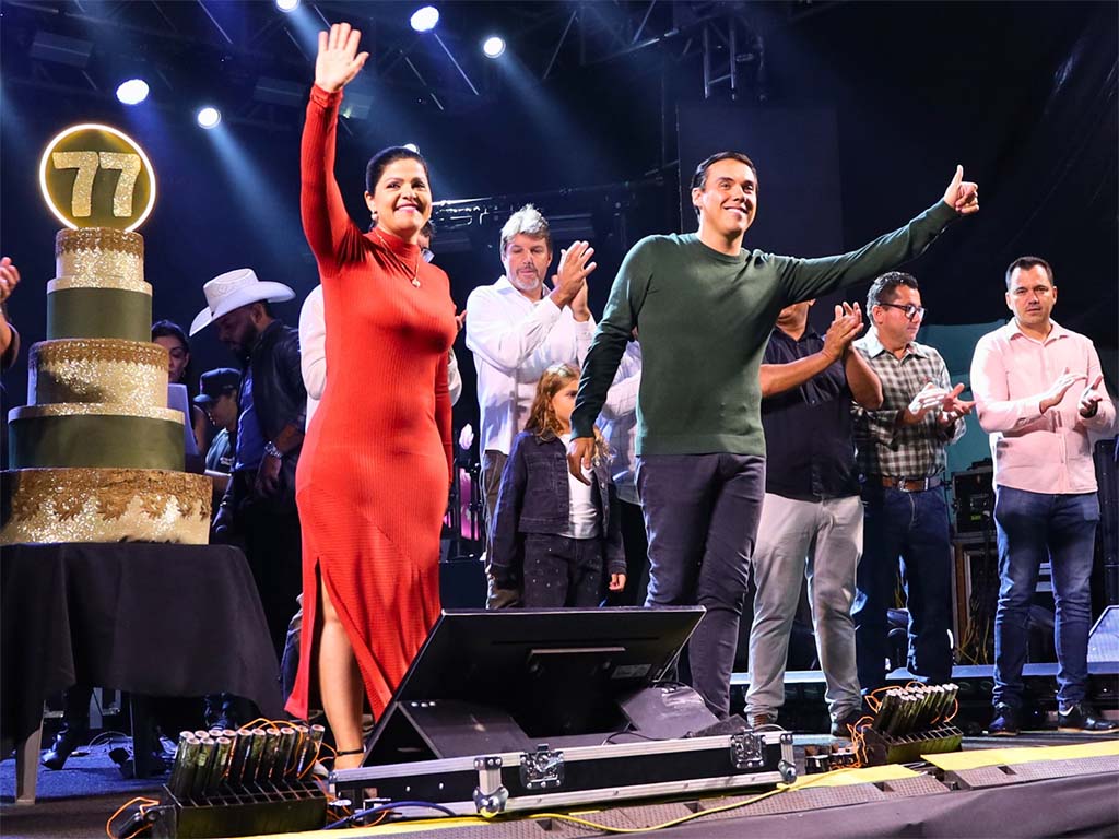 Pessoas celebrando com bolo em evento festivo.