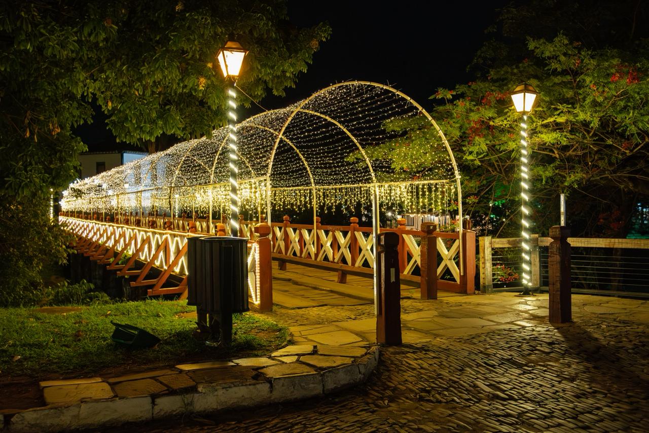 Ponte iluminada à noite com decoração festiva.