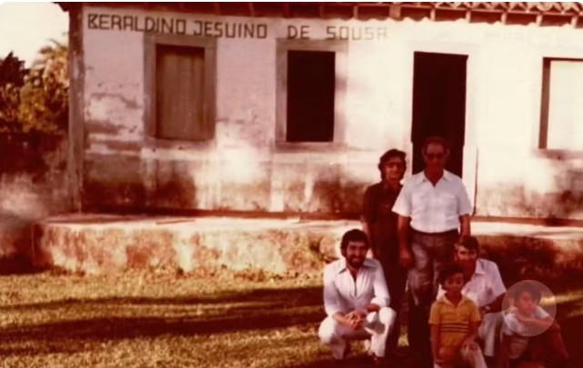 Pessoas em frente a uma casa antiga.