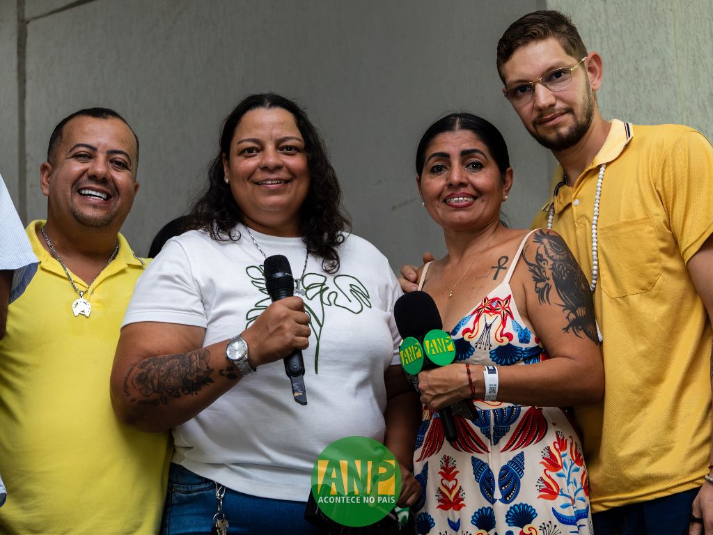 Grupo de pessoas com microfones, sorrindo.