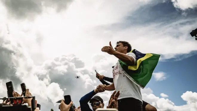 Pessoa com bandeira do Brasil em manifestação.