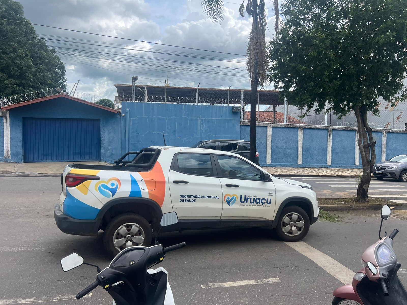 Carro da Secretaria Municipal de Saúde estacionado na rua.