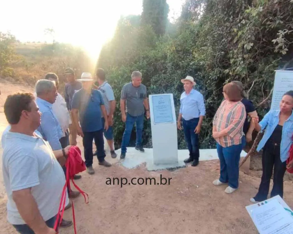 Grupo de pessoas em volta de uma placa inaugural.
