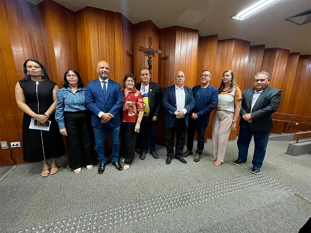Pessoas em pé em frente a uma parede de madeira.